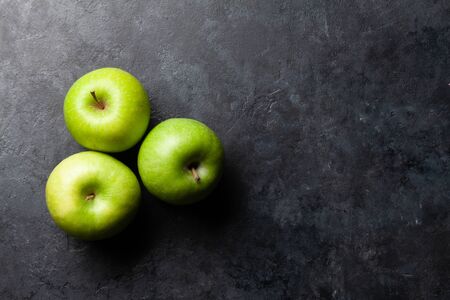 Ripe green apple fruits on dark stone table. Top view with copy space. Flat layの写真素材