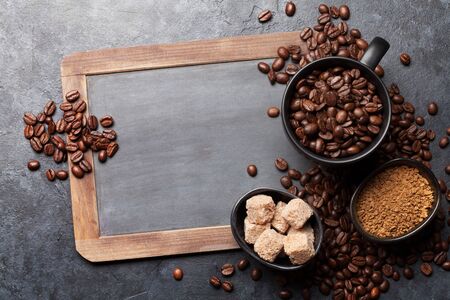 Coffee cup with roasted beans on dark stone table. Top view with chalkboard copy space. Flat layの写真素材