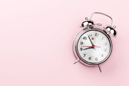 Pink workplace desk table with alarm clock. Morning or deadline concept. Top view with space for your text. Flat layの写真素材