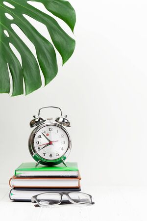 Office workplace desk table with supplies and alarm clock. Morning or deadline concept. With space for your textの写真素材
