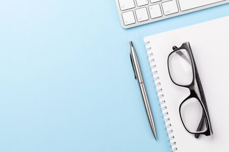 Blue workplace desk table with computer, supplies and glasses. Top view with space for your text. Flat layの写真素材