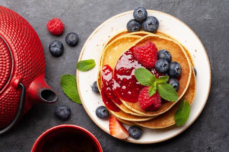 Delicious homemade pancakes with summer berries and jam for breakfast. Top view closeupの写真素材