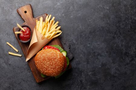 Potato fries chips with ketchup and hamburger. Fast food take away. Top view with copy space