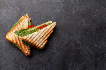 Club sandwich with ham, cheese, salad and vegetables. Fast food take away. Top view with copy space