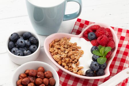 Healthy breakfast with homemade granola with yogurt and fresh berries on wooden backgroundの写真素材