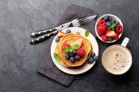Delicious homemade pancakes with summer berries and coffee for breakfast. Top view with copy spaceの写真素材