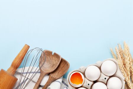 Cooking utensils and ingredients on blue background. Top view with space for your recipe or menu....