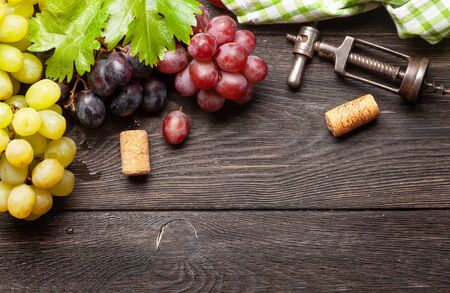 Various grapes, wine corks and corkscrew on wooden table. Top view with copy space. Flat layの写真素材