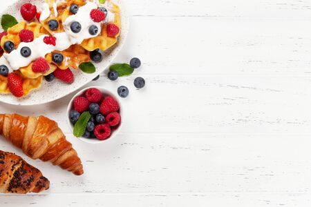 Delicious belgian waffles with ice cream and summer berries. Top view with copy spaceの写真素材