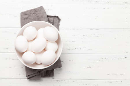 White chicken eggs on wooden table. Top view with copy space. Flat layの写真素材