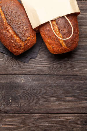 Homemade organic bread with seeds on wooden table. Top view flat lay with copy spaceの写真素材