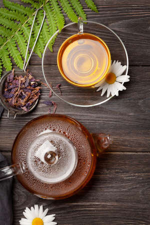 Herbal tea in teapot and cup on wooden table. Top view. Flat layの写真素材