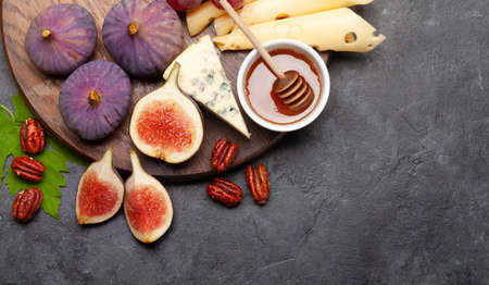 Antipasto plate with cheese, figs and grapes. Appetizer board. Top view flat lay with copy space