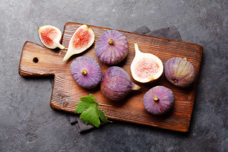 Ripe sweet figs on cutting board. Top view flat lay