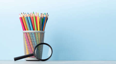 Office supplies and school items in front of blue wall with copy space for your textの写真素材