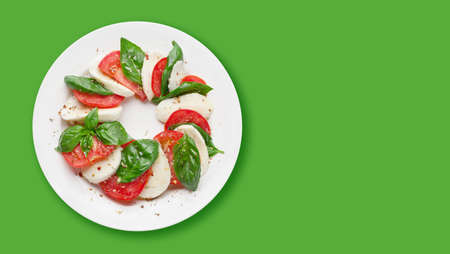 Caprese salad. Mozzarella cheese, tomatoes and basil herb leaves. Top view flat lay with copy spaceの写真素材