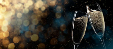 Christmas and New Year wide bokeh backdrop. Xmas greeting card template background with champagne glasses and copy spaceの写真素材