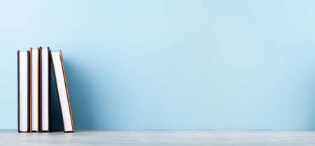 Office notepad supplies and school book items in front of blue wall with copy space for your text