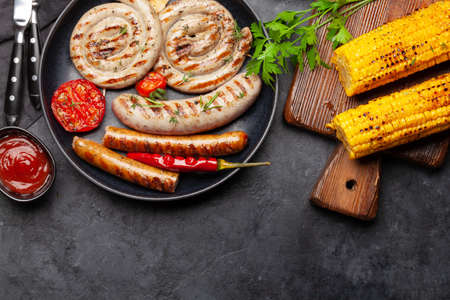 Grilled sausages and vegetables with spices and herbs. Top view flat lay with copy spaceの写真素材