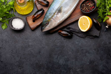 Raw fish cooking. Seafood and ingredients for dinner on stone table. Top view flat lay with copy spaceの写真素材