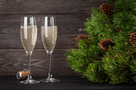 Christmas greeting card with fir tree and two champagne glassesの写真素材