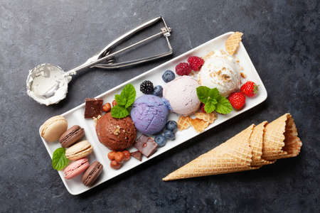 Berry, vanilla and chocolate ice cream sundae and macaroon sweets. Top view flat lay