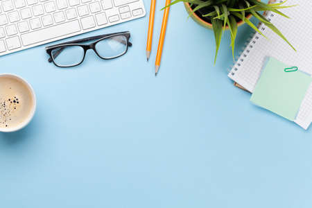 Business desk workplace and office objects over blue backdrop. Top view flat lay with copy space for...