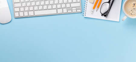 Business desk workplace and office objects over blue backdrop. Top view flat lay with copy space for...