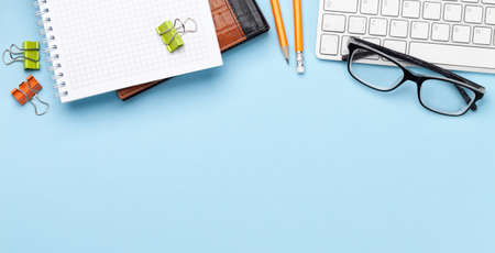 Business desk workplace and office objects over blue backdrop. Top view flat lay with copy space for...