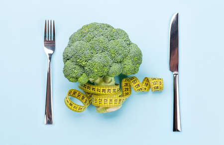 Broccoli and tape measure. Healthy food and weigh loss concept. Diet and fitness. Top view flat layの写真素材