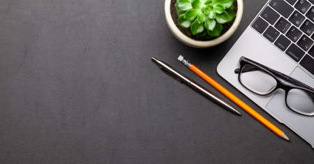 Business desk workplace and office objects over black leather backdrop. Top view flat lay with copy...