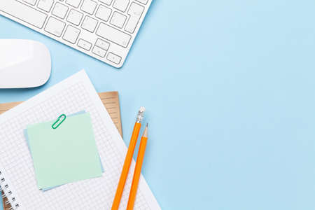 Business desk workplace and office objects over blue backdrop. Top view flat lay with copy space for...