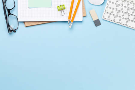 Business desk workplace and office objects over blue backdrop. Top view flat lay with copy space for...