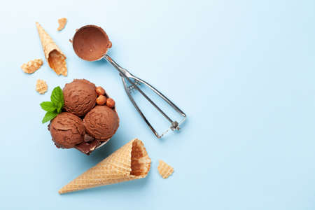 Chocolate ice cream with nuts and waffle cones. Top view flat lay with copy space