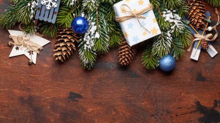 Christmas greeting card with fir tree and decor on wooden background and copy space for your xmas greetings. Top view flat lay