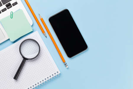 Business desk workplace and office objects over blue backdrop. Top view flat lay with copy space for...