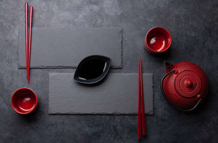 Stone plates and chopsticks on black table settingの写真素材