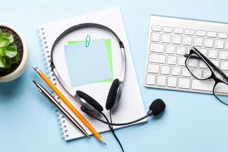 Office desk with headset and supplies. Remote office and work from home concept. Top veiw flat lay with copy spaceの写真素材