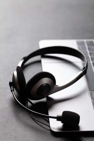 Office desk with headset and laptop. Remote office and work from home concept. With copy spaceの写真素材