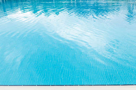 Sunny swimming pool in tropical resort. Summer vacation concept with copy space
