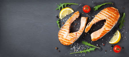Grilled salmon and spices on stone wide background. Top view flat lay with copy spaceの写真素材