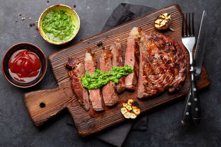 Sliced beef steak with sauces. On cutting board. Top view flat lay