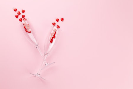 Valentines day card with champagne glasses and heart shaped sweets. Top view flat lay with copy spaceの写真素材
