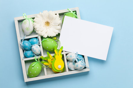 Easter greeting card with gerbera flowers and colorful easter eggs. Top view flat lay with space for...