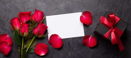 Valentines day greeting card with red rose flowers and gift box. Top view flat lay with space for your greetingsの写真素材