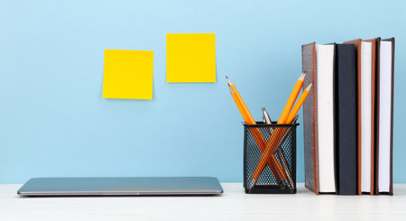 Studio workspace with laptop computer and office supplies. With yellow stickers for copy space