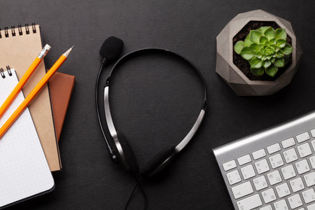 Office desk with headset and supplies. Remote office and work from home concept. Top view flat layの写真素材