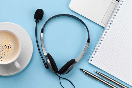 Office desk with headset, coffee and laptop. Remote office and work from home concept