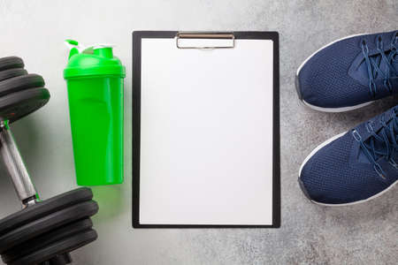 Sneakers and dumbbells. Sport, fitness and healthy lifestyle background. Top view flat lay with copy...