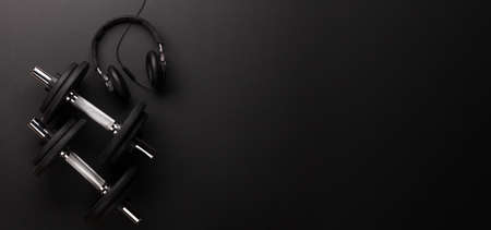 Headphones and dumbbells. Sport, fitness and healthy lifestyle background. Top view flat lay with copy spaceの写真素材
